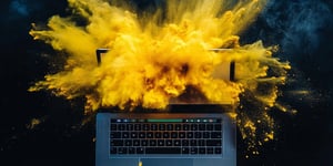 Explodierender Laptop mit gelben Staubwolken